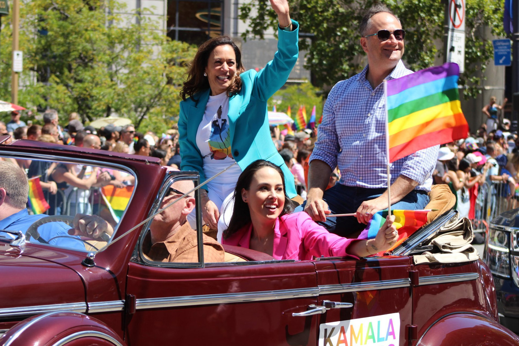Vice President Harris smiles at a crowd at the Pride Parade in San Francisco, CA, accompanied with her husband, Doug, and her niece, Meena
